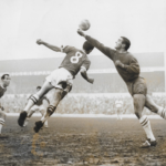 Millwall keeper Reg Davies punches the ball away from the head of 21 year old Arfon Griffiths. Credit: AFCArchive
